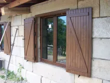 ventana de madera estilo rústica en fachada con contraventanas en z